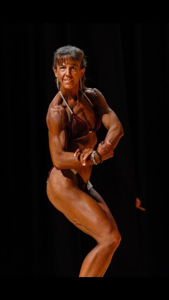 Melissa Verdi, survivor of childhood sexual abuse, posing at a bodybuilding competition